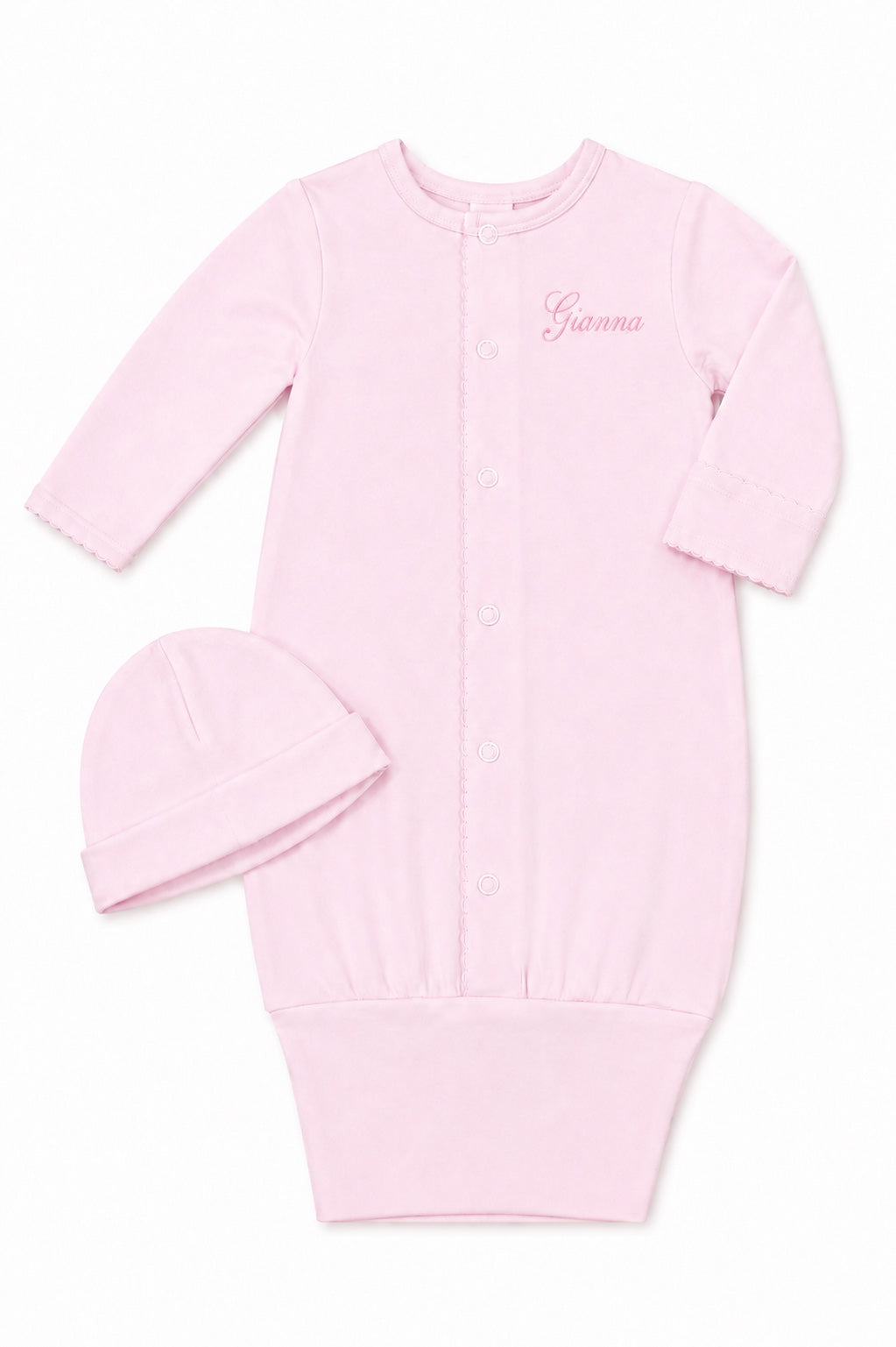 Carriage Boutique pink newborn sleep sack with matching hat, featuring scalloped cuffs and custom name embroidery.