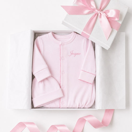 Carriage Boutique pink newborn sleep sack and matching hat with personalized name embroidery in a gift box.