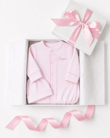 Carriage Boutique pink newborn sleep sack and matching hat with personalized name embroidery in a gift box.