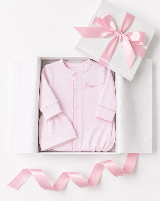 Carriage Boutique pink newborn sleep sack and matching hat with personalized name embroidery in a gift box.