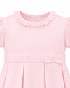 Carriage Boutique pink pique baby girl dress with a ruffled collar, pleated skirt, and delicate waist bow detail.