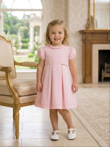 Carriage Boutique pink pique toddler girl dress with puff sleeves and pleated skirt worn by a young girl