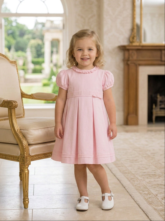 Carriage Boutique pink pique toddler girl dress with puff sleeves and pleated skirt worn by a young girl