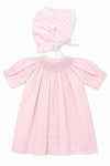 Carriage Boutique pink cotton baby dress with rosebud print, smocked bodice, and matching lace-trimmed bonnet.