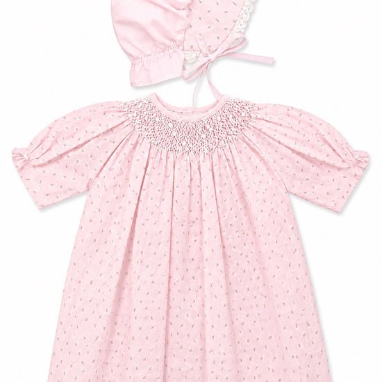 Carriage Boutique pink cotton baby dress with rosebud print, smocked bodice, puff sleeves, and matching lace bonnet.