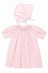 Carriage Boutique pink cotton baby dress with rosebud print, smocked bodice, puff sleeves, and matching lace bonnet.
