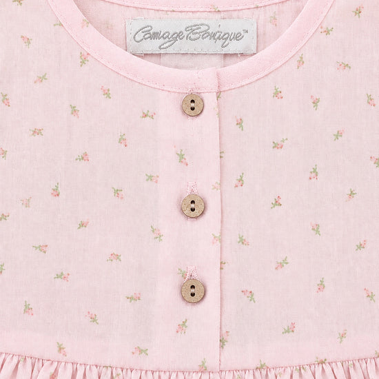 Carriage Boutique baby girl dress in soft pink with a delicate rosebud print, featuring wooden buttons and a round neck