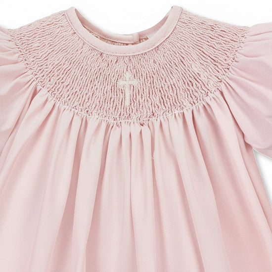 Carriage Boutique pink hand-smocked bishop dress with pearl cross detail and matching bonnet. 100% cotton.