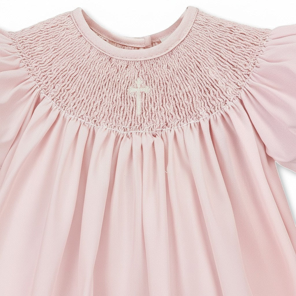 Carriage Boutique pink hand-smocked bishop dress with pearl cross detail and matching bonnet. 100% cotton.