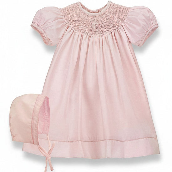 Carriage Boutique pink hand-smocked bishop dress with pearl cross detail and matching bonnet. 100% cotton.