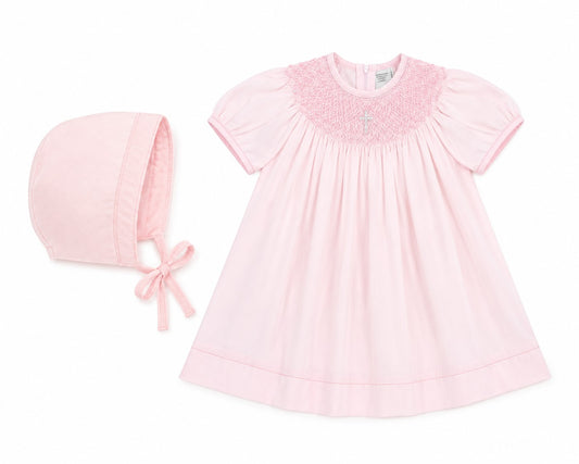 Carriage Boutique baby girl pink cotton bishop dress with hand-smocked pearl cross detail and matching bonnet.