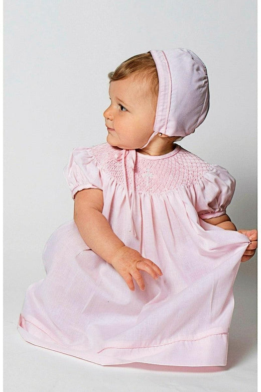Carriage Boutique baby girl pink cotton bishop christening dress with hand-smocked detail and matching bonnet