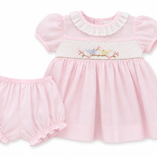 Carriage Boutique baby girl pink dress with hand smocking, bird embroidery, and matching ruffled bloomers.