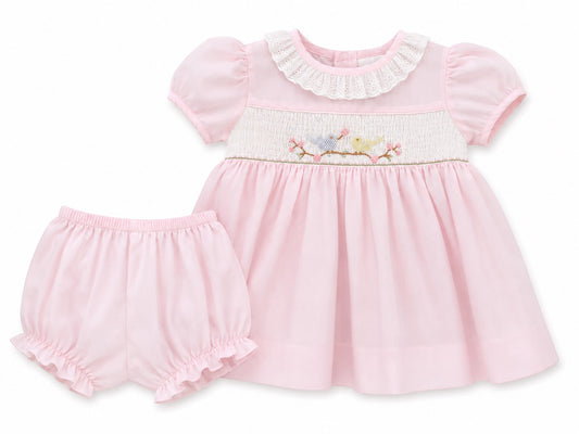 Carriage Boutique baby girl pink dress with hand smocking, bird embroidery, and matching ruffled bloomers.