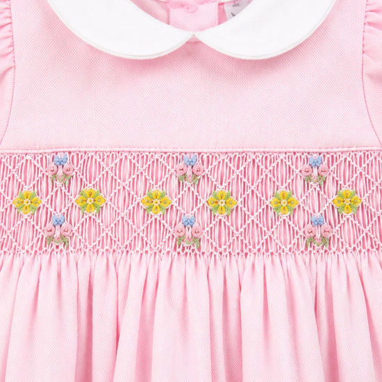Carriage Boutique pink pique baby girl dress with white peter pan collar and hand-smocked floral waist detail