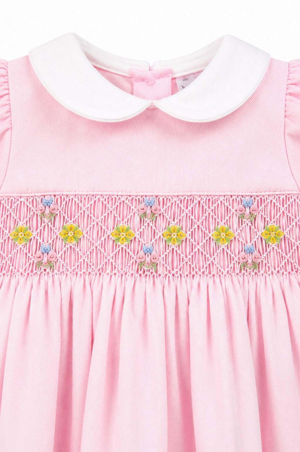 Carriage Boutique pink pique baby girl dress with white peter pan collar and hand-smocked floral waist detail