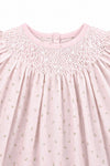 Carriage Boutique pink cotton baby dress featuring delicate rosebud print and intricate white hand-smocked detailing.