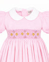 Carriage Boutique pink toddler dress with white collar, short sleeves, and delicate smocked yellow flower embroidery.
