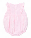 Carriage Boutique baby girl bubble romper in soft pink with Swiss dot texture, ruffled shoulders, and back buttons.