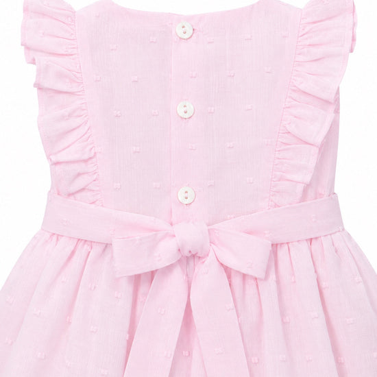 Carriage Boutique baby girl pink Swiss dot dress with ruffled sleeves, back button closure, and a decorative waist bow