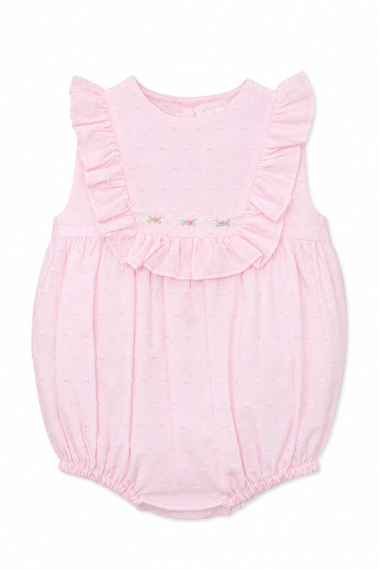Carriage Boutique baby girl bubble romper in soft pink with Swiss dot texture, ruffled shoulders, and floral detail.