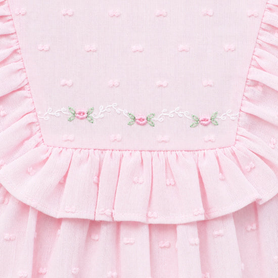 Carriage Boutique pink baby bubble romper with Swiss dot texture, ruffled yoke, and delicate floral embroidery.