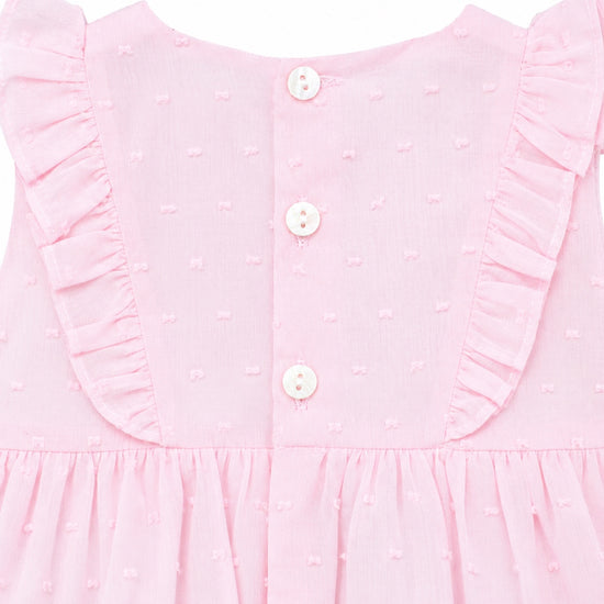 Carriage Boutique baby girl bubble romper in soft pink with Swiss dot texture, ruffled shoulders, and button back.