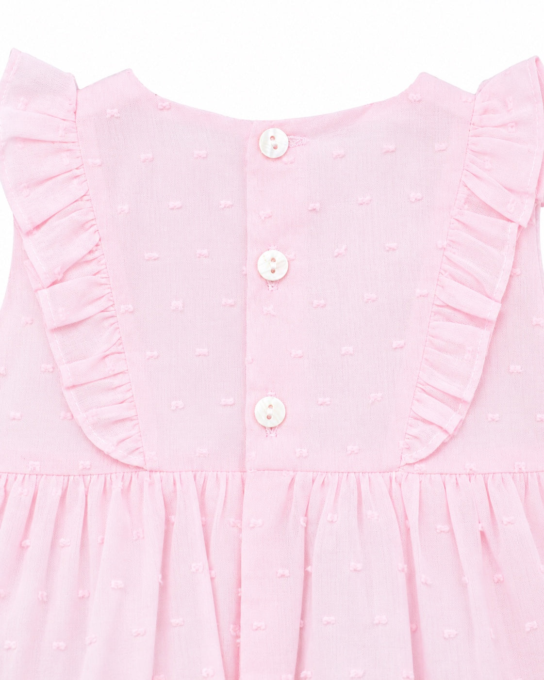 Carriage Boutique baby girl bubble romper in soft pink with Swiss dot texture, ruffled shoulders, and button back.