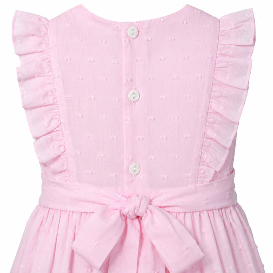 Carriage Boutique pink toddler dress with Swiss dot texture, ruffled sleeves, button back, and a tied waist sash.