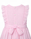 Carriage Boutique pink toddler dress with Swiss dot texture, ruffled sleeves, button back, and a tied waist sash.