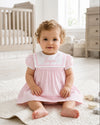 Carriage Boutique pink and white short sleeve toddler dress with embroidered sailor collar on a baby sitting on a rug