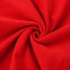 Close-up of Carriage Boutique red corduroy fabric with a soft, textured swirl pattern for baby clothing.
