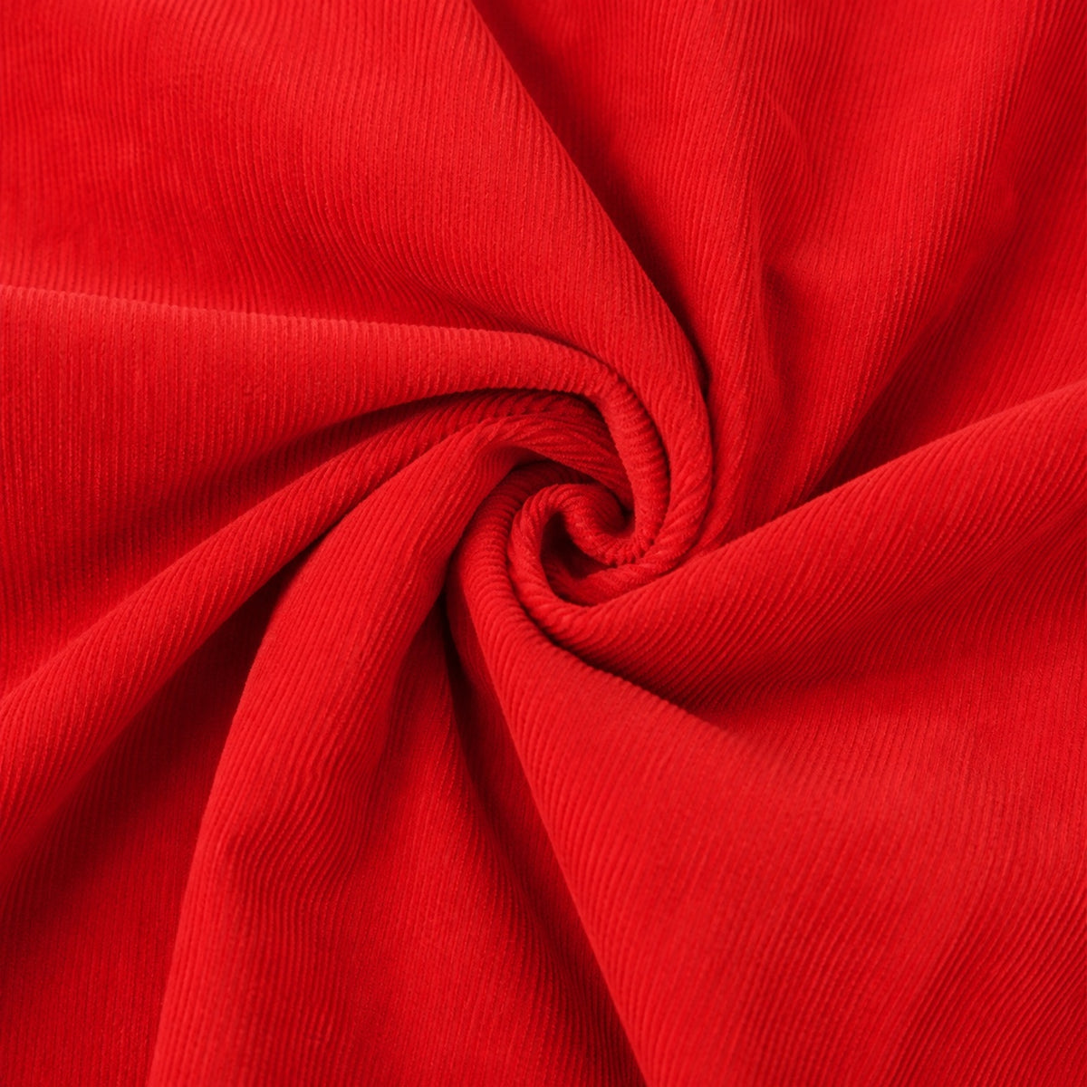 Close-up of Carriage Boutique red corduroy fabric with a soft, textured swirl pattern for baby clothing.