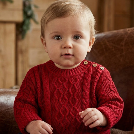 Carriage Boutique red fisherman knit pullover sweater worn by a baby with button shoulder detail