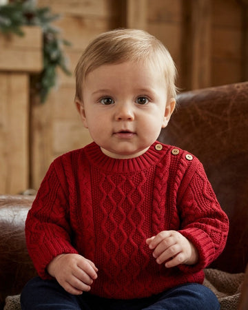Carriage Boutique red fisherman knit pullover sweater worn by a baby with button shoulder detail