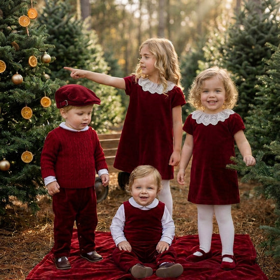 Carriage Boutique red fisherman knit pullover sweater worn by a toddler boy with a matching cap in a forest setting.
