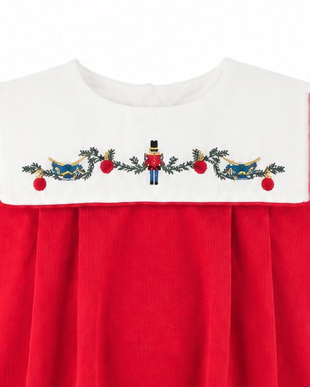 Carriage Boutique red cotton baby boy bubble romper featuring a white smocked bib with embroidered nutcracker motif.