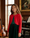 Carriage Boutique red bolero sweater with pearl accents worn by a young girl over a green velvet dress