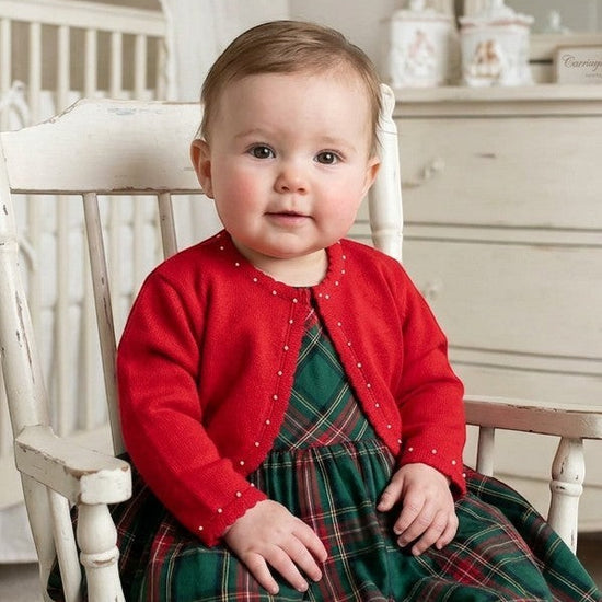 Carriage Boutique red baby girl bolero sweater with pearl accents worn over a green plaid dress