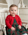 Carriage Boutique red baby girl bolero sweater with pearl accents worn over a green plaid dress