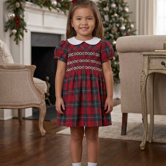Carriage Boutique red plaid smocked dress with white Peter Pan collar and puff sleeves worn by a young girl