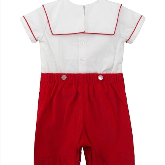 Carriage Boutique red and white cotton infant boy bobbie suit with smocked bib and wooden soldier motif.