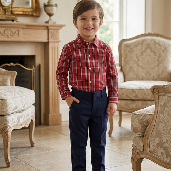Carriage Boutique toddler boy wearing a red and white plaid long sleeve cotton shirt with navy blue trousers