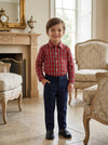 Carriage Boutique toddler boy wearing a red and white plaid long sleeve cotton shirt with navy blue trousers