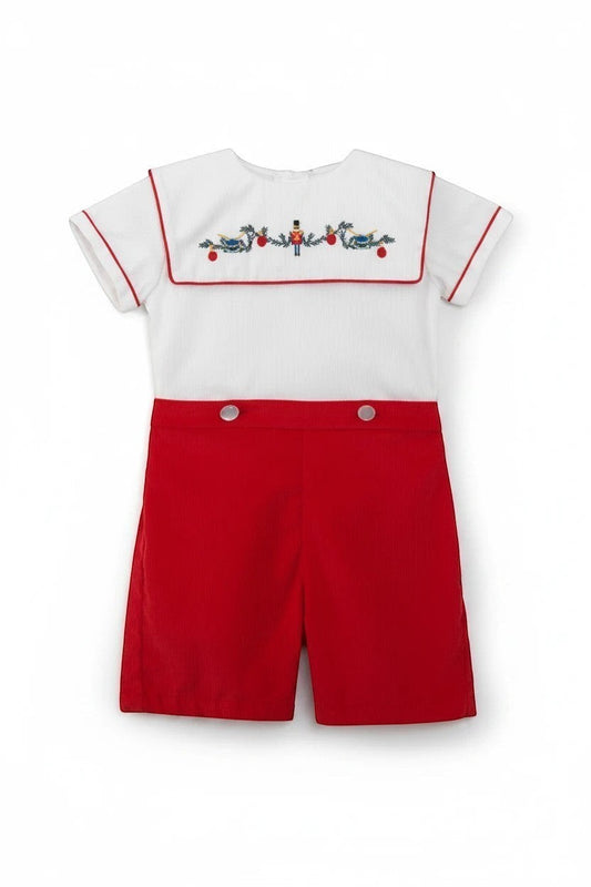 Carriage Boutique red corduroy shorts and white smocked bib shirt with wooden soldier and bird embroidery. 100% cotton.