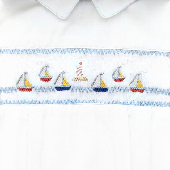 Carriage Boutique white bubble romper with smocked sailboat and lighthouse embroidery, Peter Pan collar, and blue piping.