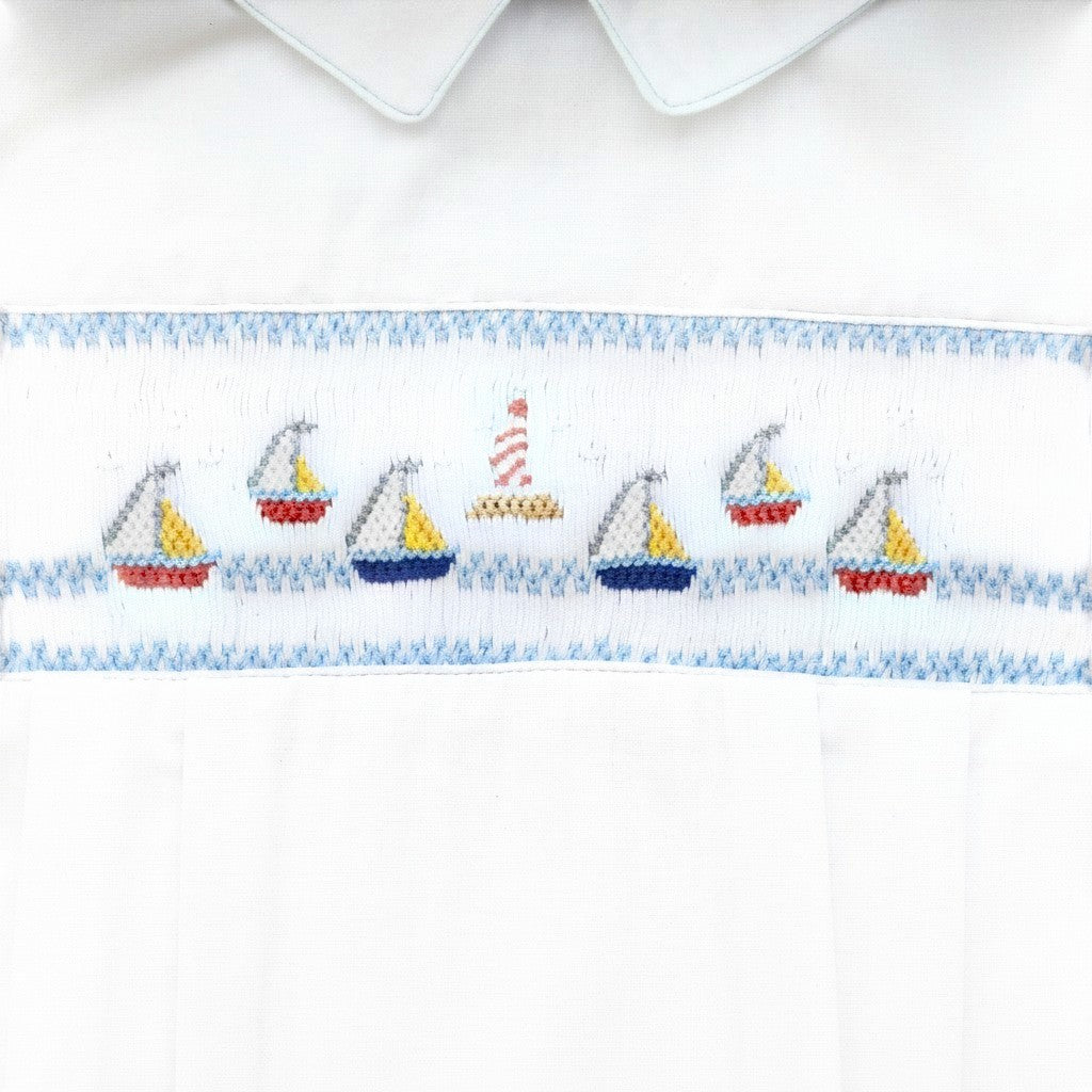 Carriage Boutique white bubble romper with smocked sailboat and lighthouse embroidery, Peter Pan collar, and blue piping.