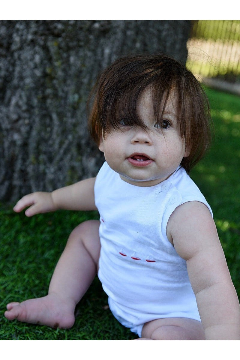 Carriage Boutique white sleeveless baby bubble with smocked detailing and embroidered red sailboats.