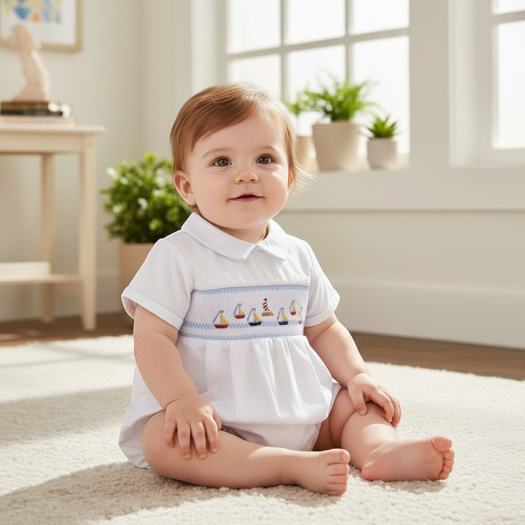 Carriage Boutique white bubble romper with smocked sailboat and lighthouse embroidery, Peter Pan collar, and blue piping.