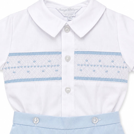 Carriage Boutique infant boy bobby suit with white collared shirt, hand smocking, and light blue cotton shorts.